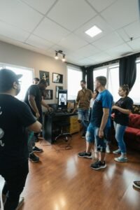 Group of people gathered around a computer discussing video editing in a modern studio setting.